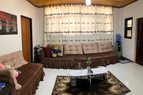 a living room with a couch and a teddy bear at Villa Lourdes in Alaminos