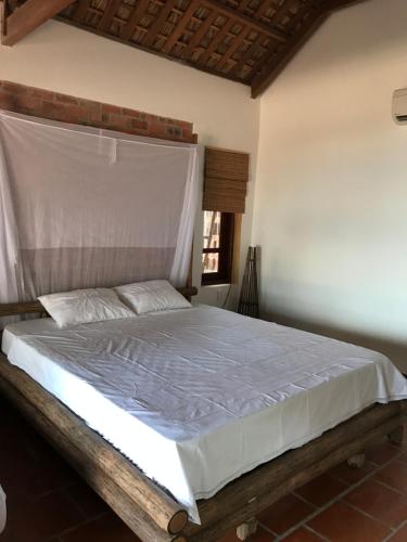 a bedroom with a white bed with a wooden frame at Phu Quoc Kim 2 Beach Front Resort in Phú Quốc