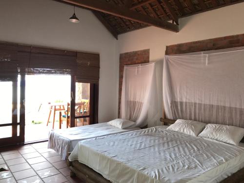 a bedroom with a bed with a mosquito net at Phu Quoc Kim 2 Beach Front Resort in Phu Quoc
