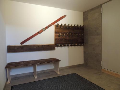 a room with a bench and a sword on the wall at Buttererhof-Apartments in Fulpmes