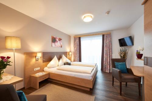 a hotel room with a bed and a desk at Frühstückshotel Birkenhof in Rauris