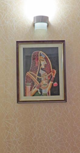 a picture of a woman on a wall at Hotel Rangoli in Jaipur