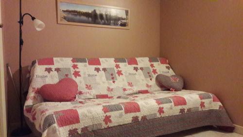 Una cama con un edredón con dos corazones. en gite la Pinetterie, en Civray-de-Touraine