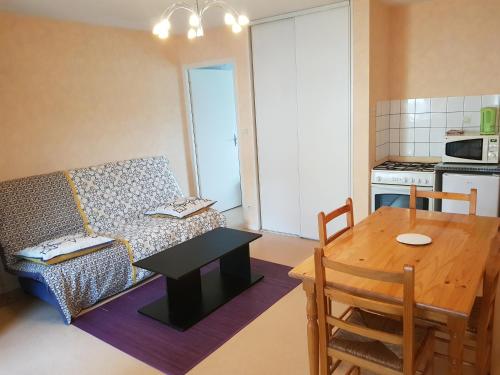 sala de estar con sofá, mesa y cocina en L'Oustalou en Viéville