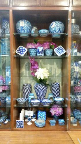 a shelf filled with blue and white plates and vases at Hotel Rangoli in Jaipur