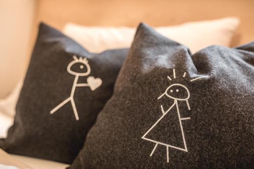 two pillows with drawings of a man and a woman at XL Appartements Sand in Taufers in Campo Tures