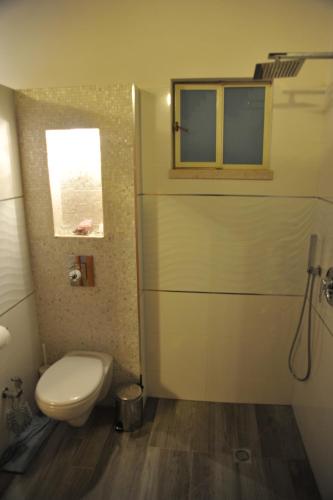 a bathroom with a toilet and a window at Aleen Guest House in Nazareth