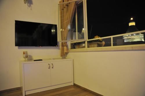 a living room with a flat screen tv and a window at Aleen Guest House in Nazareth