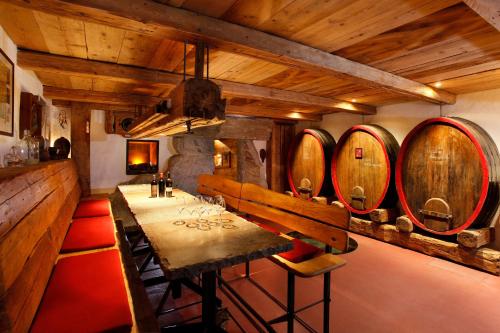 a dining room with a table and a bunch of wine barrels at Family Apartment Bacchus in Marlengo