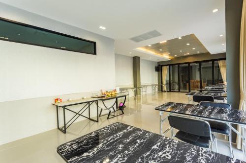 a row of tables and chairs in a room at Grand Inter Hotel in Samut Sakhon