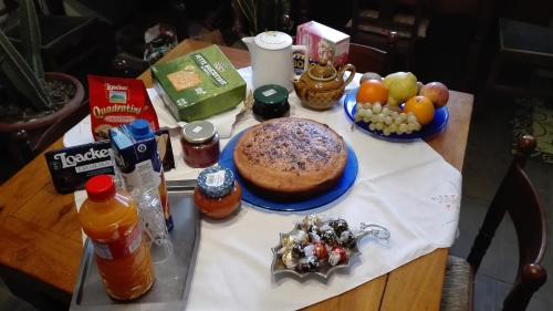 フォルリにあるB&B La Doganaのケーキと果物を載せたテーブル