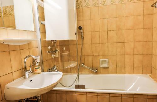 a bathroom with a sink and a tub and a mirror at Apartment Lakeside in Turracher Hohe