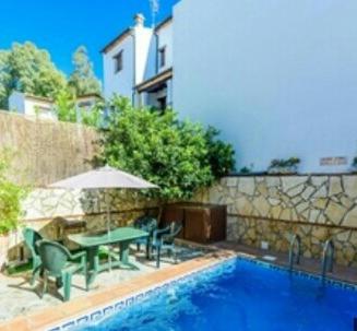 a patio with a table and chairs next to a pool at Casa rural Huerta San Miguel 2010 in El Bosque
