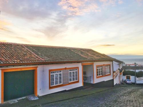 a small white house with a view of the ocean at Casa do Pisão - Cosy and Modern Two-Bedroom Townhouse in Angra do Heroísmo