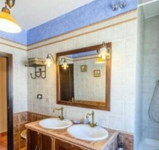 a bathroom with two sinks and a mirror at Casa rural Huerta San Miguel 2010 in El Bosque