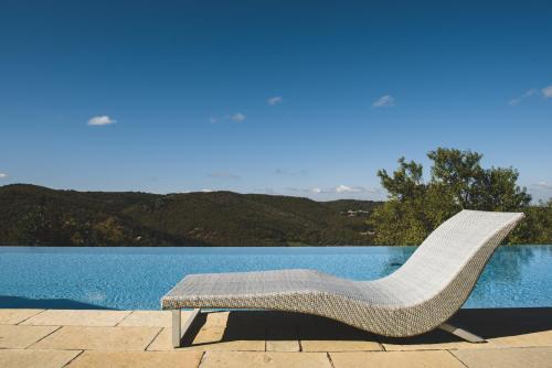 a chair sitting on a patio next to a pool at Borgo Di Pietrafitta Relais in Castellina in Chianti