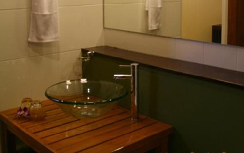 a bathroom with a glass bowl sink on a wooden table at Krabi Home Town Boutique in Krabi town