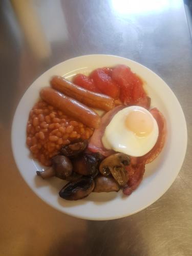 a plate of food with beans and eggs on a table at The Ratcliffe Guest House in Paignton