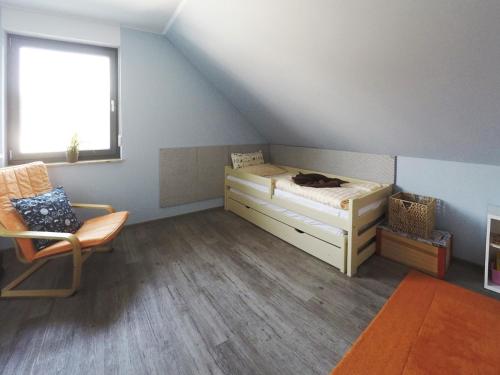 オストゼーバート・ディアーハーゲンにあるFerienwohnung Toplaterneのベッド1台、椅子、窓が備わる客室です。