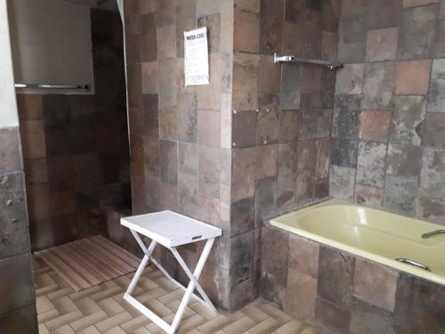 a bath tub and a stool in a bathroom at Puccini House in Windhoek