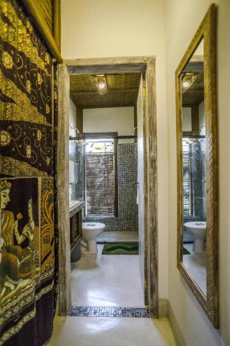 a bathroom with two sinks and a toilet and a mirror at Pousada Udexere Eco House in Santo André