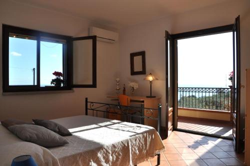 a bedroom with a bed and a balcony at Villa Gemma di Mare in Santa Teresa di Riva
