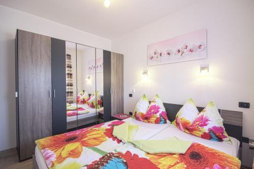 a bedroom with a large bed with colorful pillows at Villa Brcina in Pula