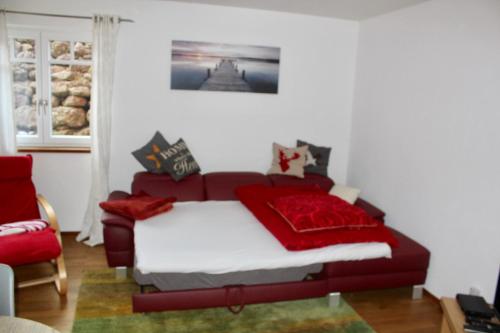 フリンツバッハにあるFerienwohnung Hilpertのベッドルーム1室(赤いベッド1台、赤い椅子付)
