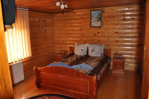a bedroom with a bed in a log cabin at Сосновий Двір in Kosiv