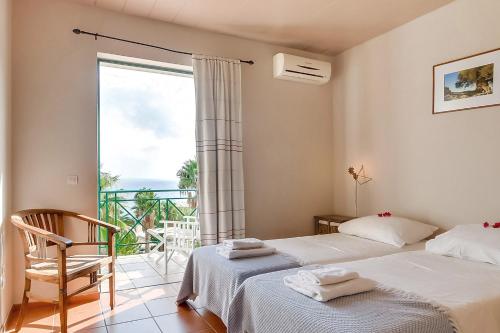 a bedroom with two beds and a large window at Villa Apostolata in Skala