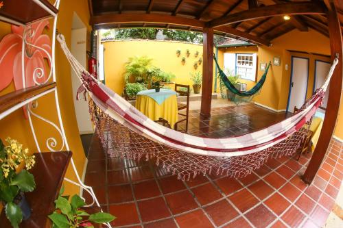 a porch with a hammock in a house at Pousada Don Diego in Ubatuba