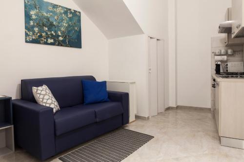 a blue couch in a living room with a painting at Blunotte Suite in Potenza