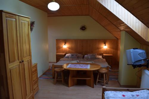 um quarto com uma cama, uma mesa e uma televisão em Penzion Micik em Zuberec