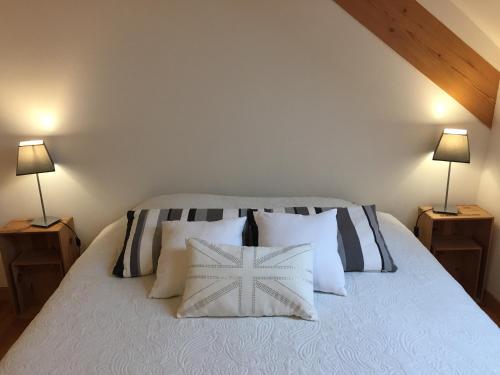 - une chambre avec un lit avec des oreillers et 2 lampes dans l'établissement Apartment thermale luxeuil, à Abelcourt