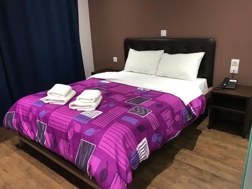 a large bed with two towels on top of it at Mansion Hotel in Athens