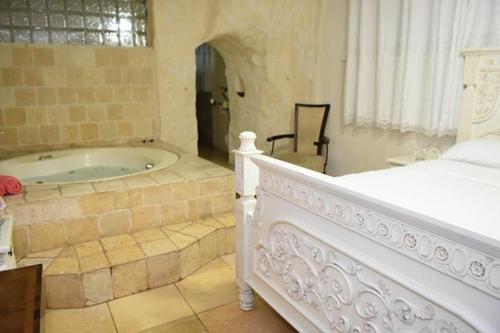 um quarto com uma banheira e uma cama num quarto em Lake Mansion em Tiberias