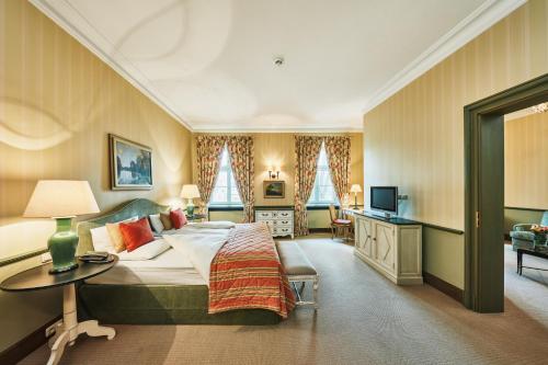 a bedroom with a bed and a table and a television at Hotel Château Bela in Belá
