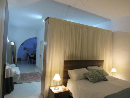a bedroom with a bed with curtains and a living room at Central Studio Apartment in Santa Venera