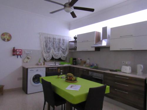 a kitchen with a table with a green table cloth at Central Studio Apartment in Santa Venera