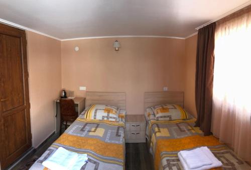 2 camas individuales en una habitación con ventana en Lia&Ramaz Guest House, en Kazbegi