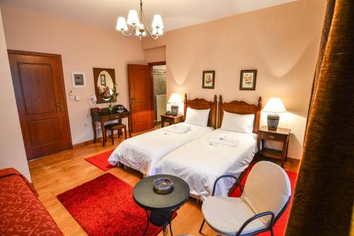 a bedroom with a bed and two chairs and a table at Karyatis Resort in Synikia Mesi Trikalon