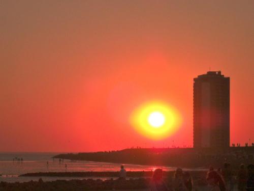 ビューズムにあるLolo's Ferienwohnungの高層ビルのある海岸の夕日