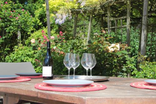 a table with two glasses and a bottle of wine at Gite 4* L'Orée des Fleurs in Grézillé