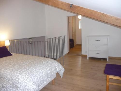 a bedroom with a bed and a dresser in a room at Gite 4* L'Orée des Fleurs in Grézillé