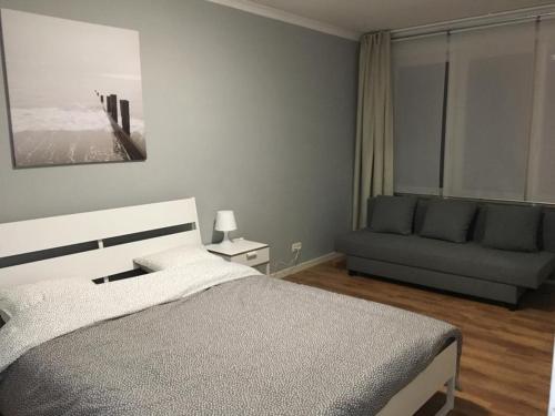sypialnia z łóżkiem i kanapą w obiekcie Hollandia City House w mieście Hasselt