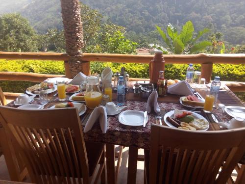 a table with food and glasses of orange juice at Bwindi Forest Lodge in Buhoma