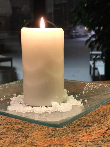 a white candle sitting on top of a table at Hotel Valbrenta in Limena