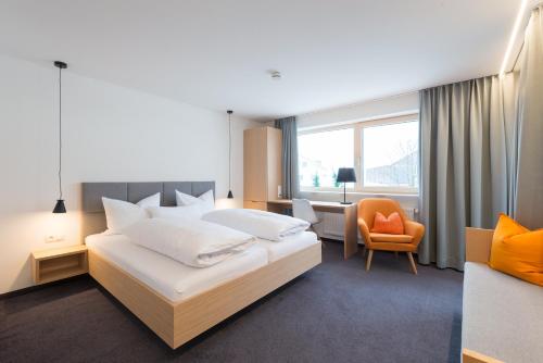 een hotelkamer met een bed en een stoel bij Pension Löwen in Andelsbuch