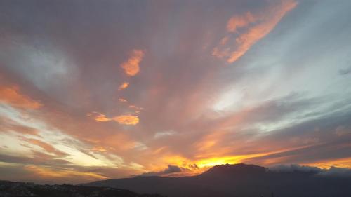 a cloudy sky at sunset with mountains in the background at Dar Swiar in Chefchaouene