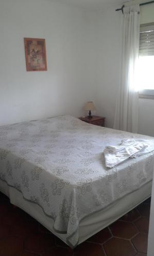 a bed in a bedroom with a table and a window at Amanitas Hotel in Villa Carlos Paz